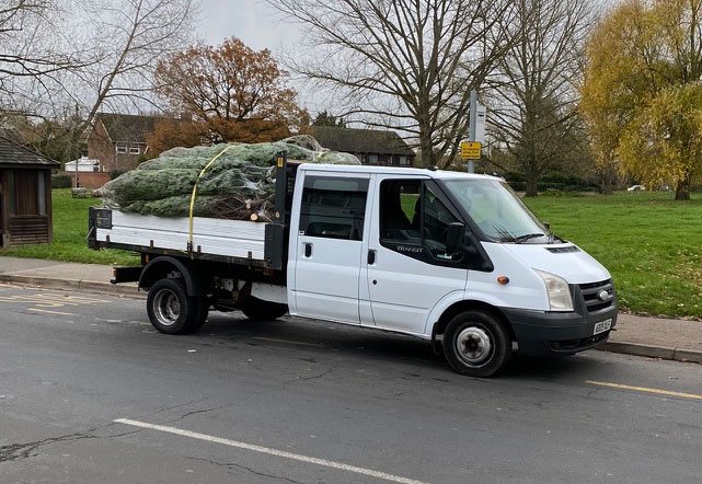 The truck loaded with netted trees
